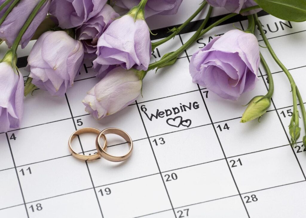 primer-plano-de-un-calendario-con-fecha-de-boda-y-flores-al-lado