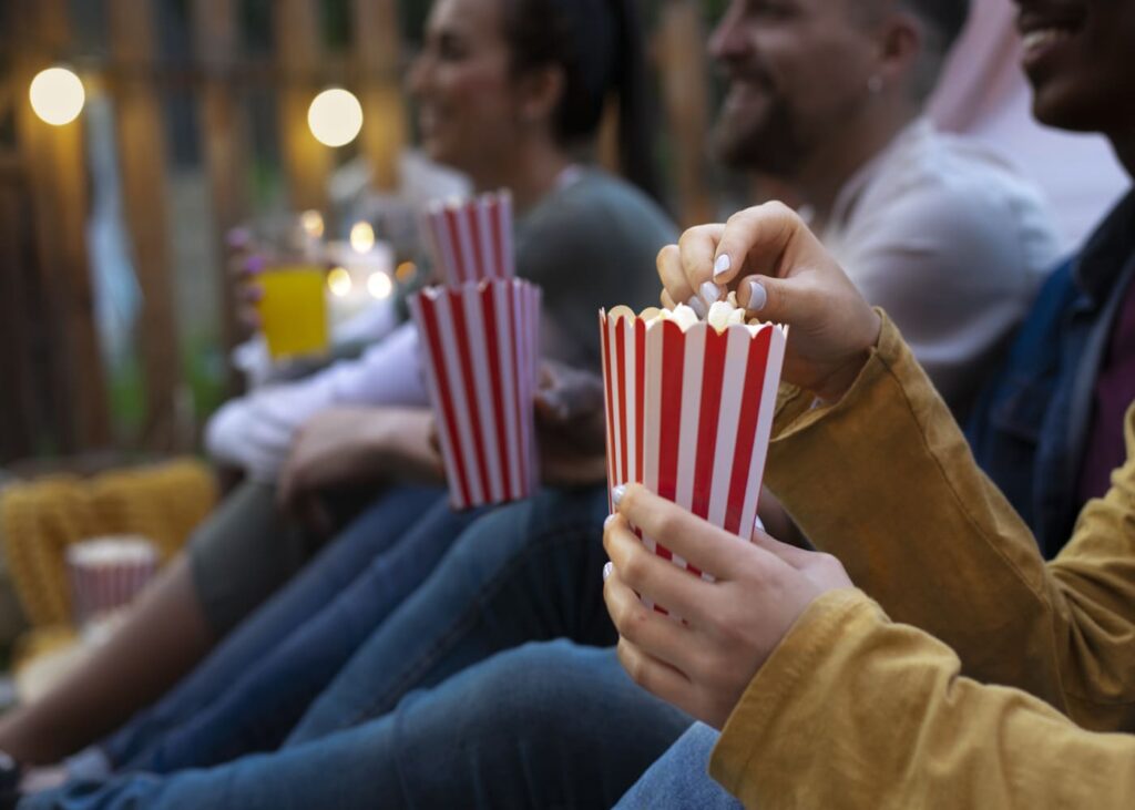 amigos-que-comen-palomitas-en-un-cine-al-aire-libre