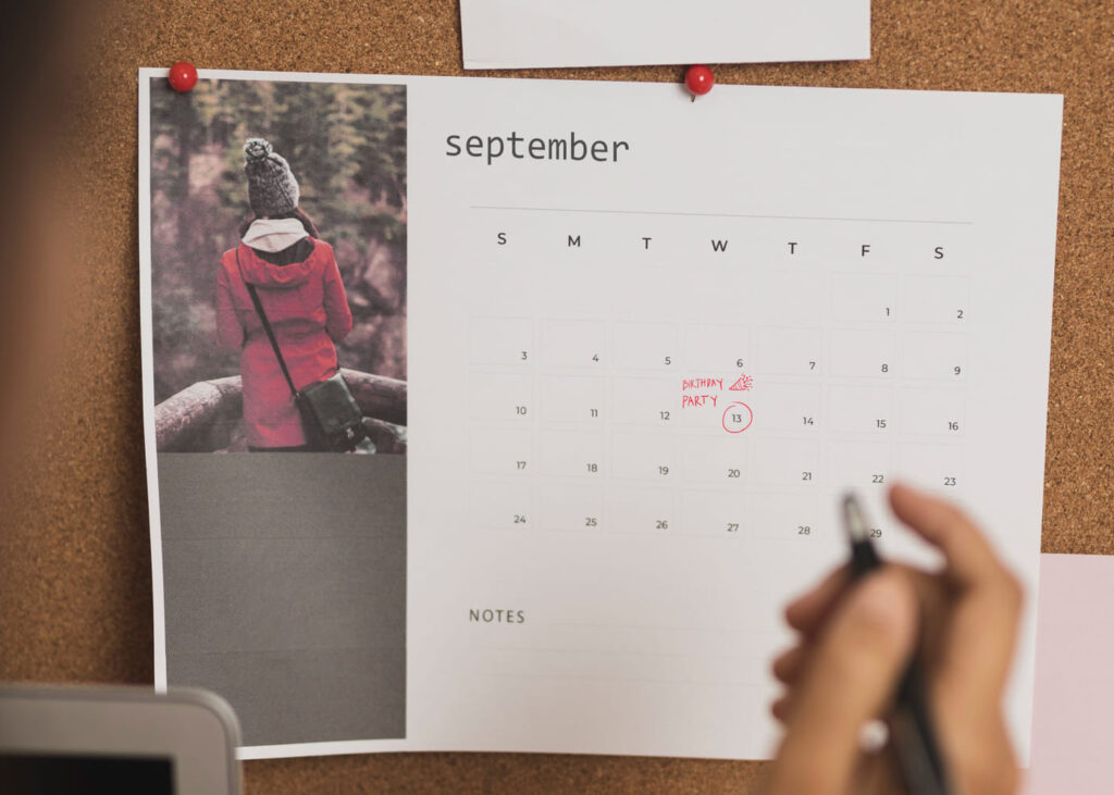 calendario-fotográfico-con-una-mano-que-sujeta-un-bolígrafo-y-que-ha-marcado-una-fecha-en-rojo