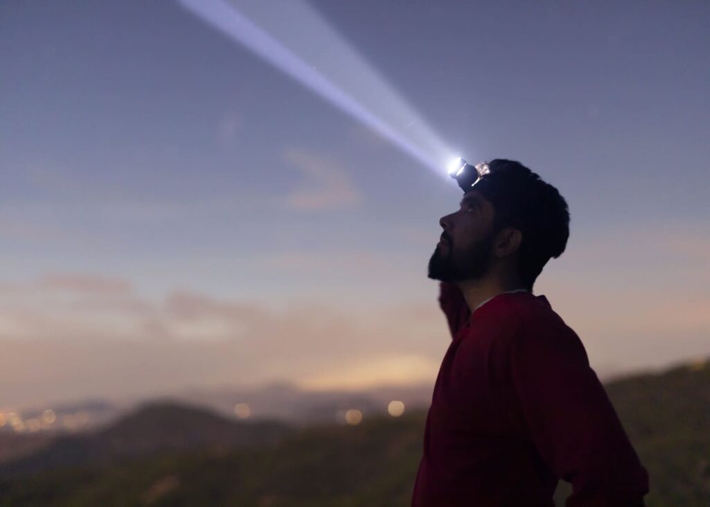 hombre-con-una-linterna-frontal-en-la-naturaleza-al-amanecer