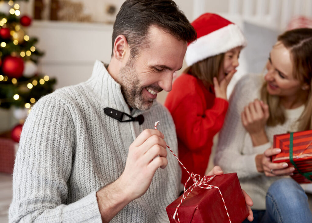 hombre-feliz-al-abrir-su-regalo-de-Navidad