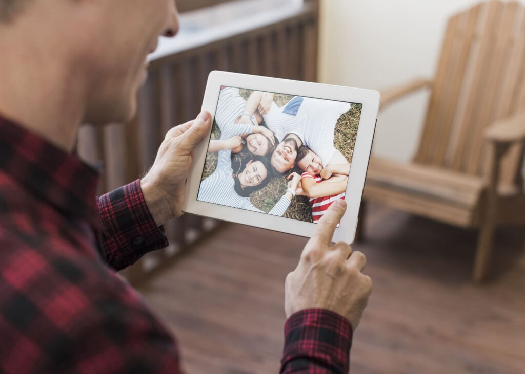hombre-que-sonrie-delante-de-una-foto-enmarcada-de-su-familia