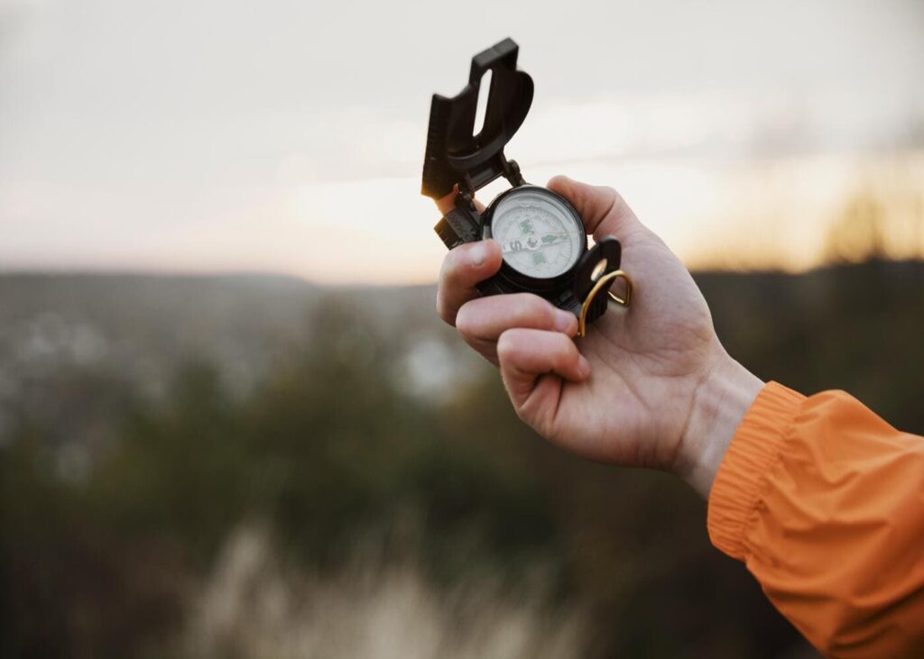 hombre-sujetando-una-brújula-en-su-mano-en-plena-naturaleza