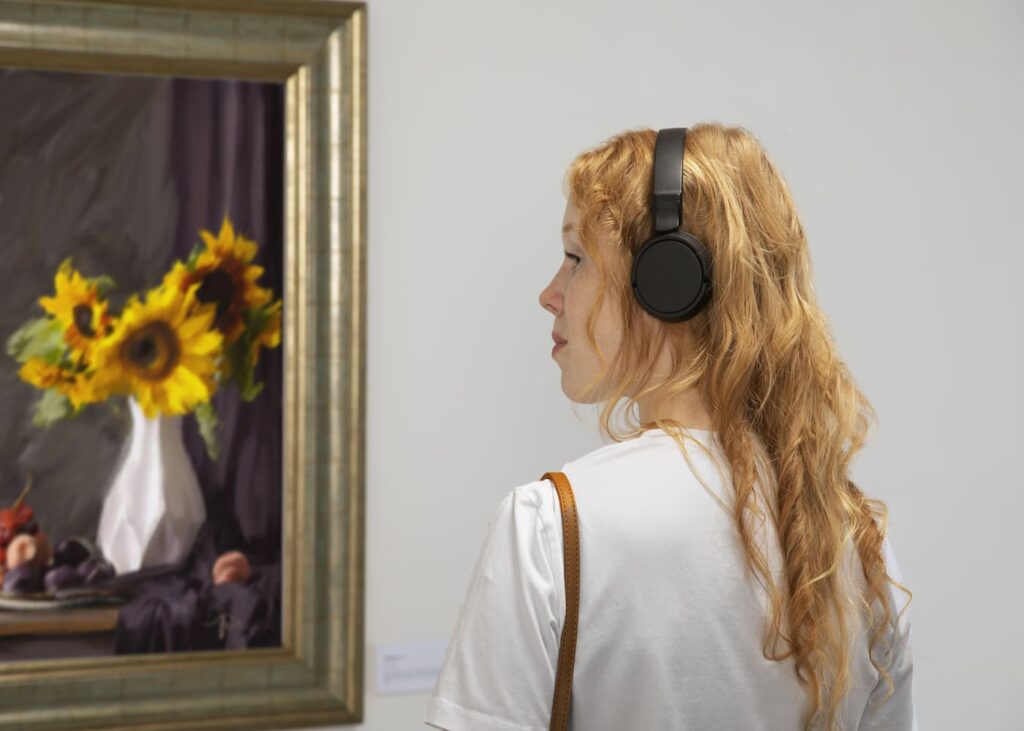 mujer-con-auriculares-que-mira-un-cuadro-de-flores-en-un-museo