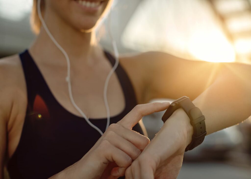 mujer-deportista-con-auriculares-que-toca-su-reloj-conectado