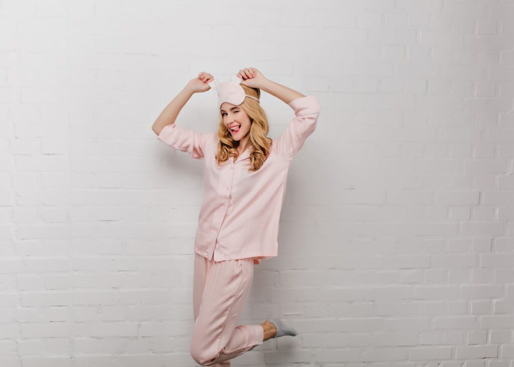 mujer-en-pijama-rosa-con-un-antifaz-para-dormir-que-saca-la-lengua