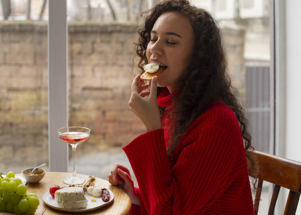 mujer-que-degusta-queso-sentada-a-una-mesa-con-los-ojos-cerrados