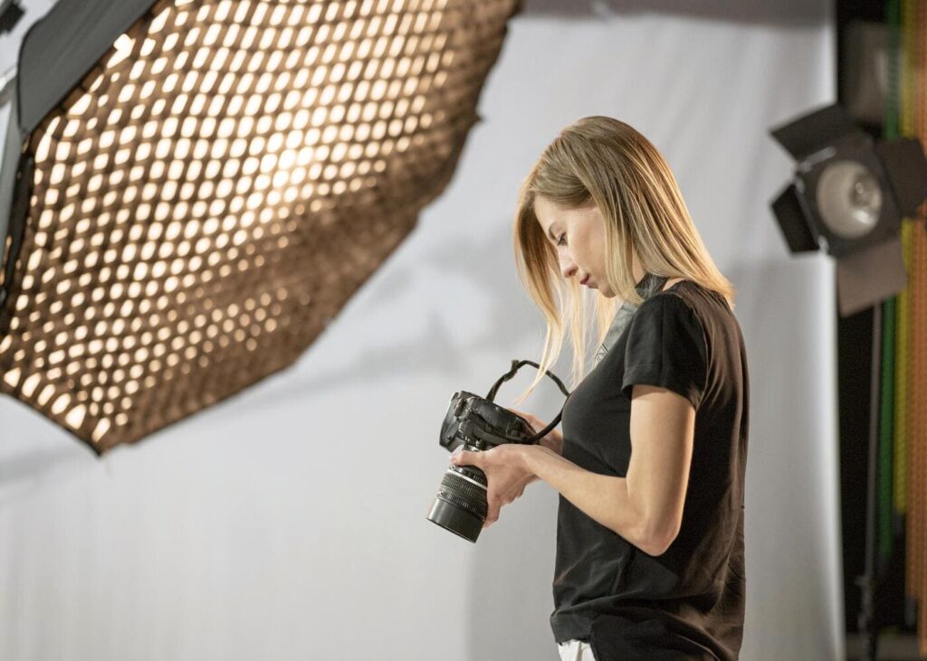 mujer-que-mira-su-camara-de-fotos-en-un-estudio