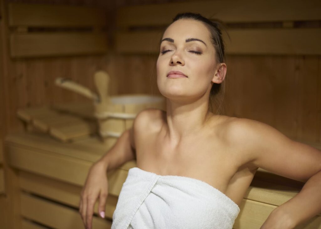 mujer-sentada-en-una-sauna-con-los-ojos-cerrados