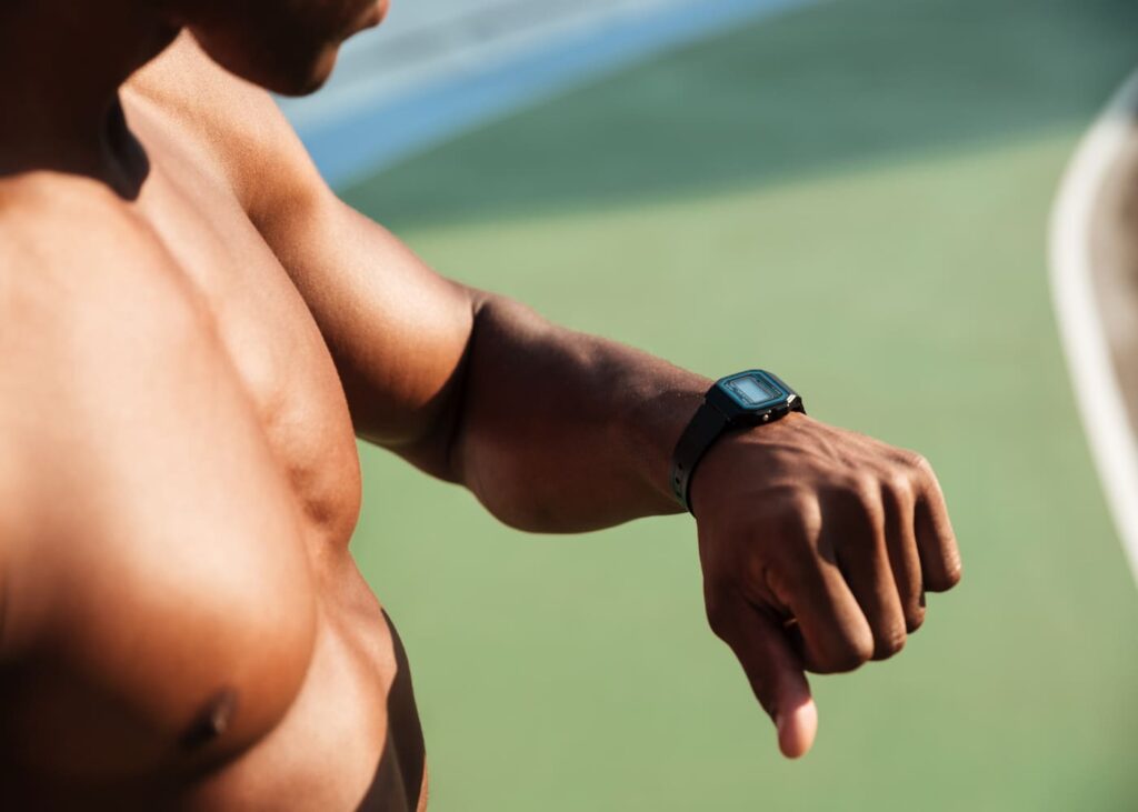 primer-plano-de-un-hombre-torso-desnudo-que-mira-su-reloj-conectado