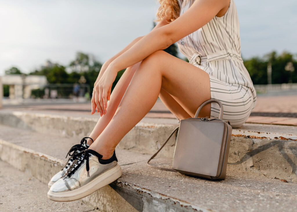 primer-plano-de-una-mujer-con-zapatillas-sentada-en-unos-escalones