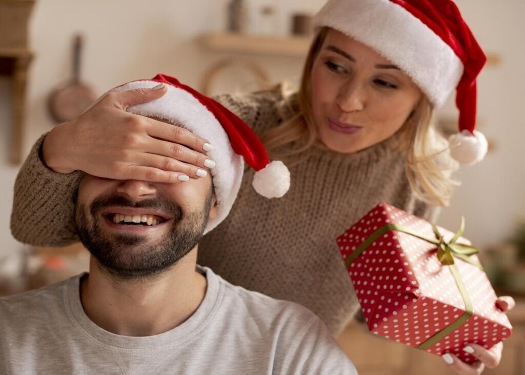 primer-plano-mujer-hombre-sorprendiendo-con-regalo-de-Navidad