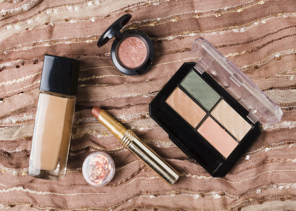 productos-de-maquillaje-colocados-sobre-una-sabana-rosa