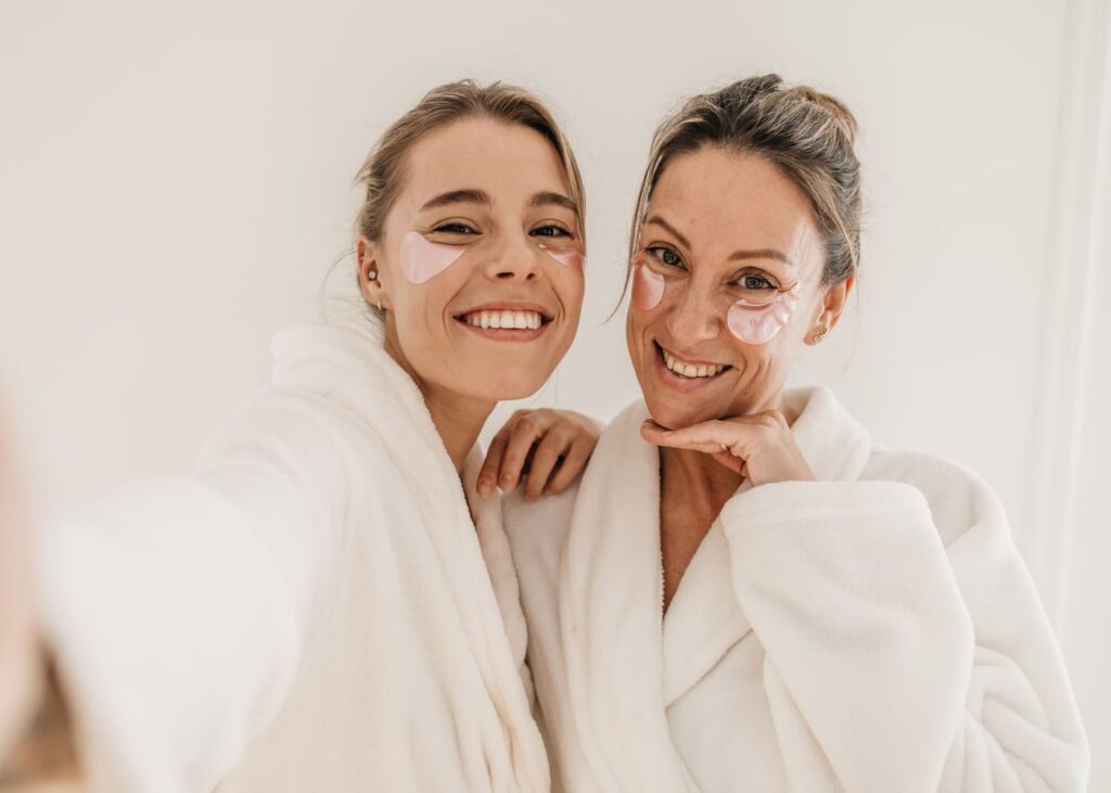 selfie-de-dos-mujeres-en-bata-en-el-spa-con-mascarilla-para-los-ojos