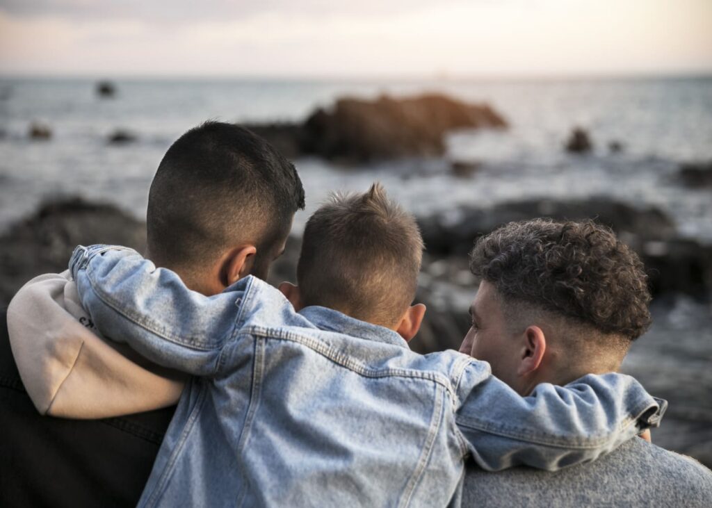 tres-hermanos-que-se-abrazan-frente-al-mar