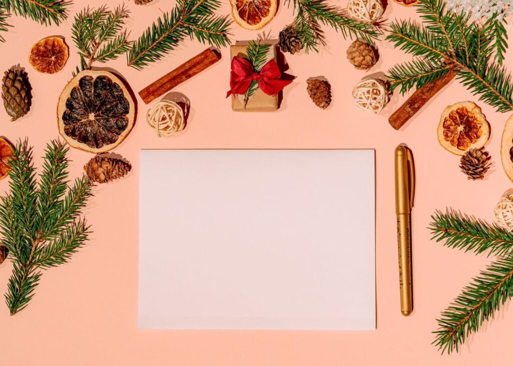 carta-blanca-sobre-una-mesa-de-madera-rodeada-de-decoraciones-de-navidad
