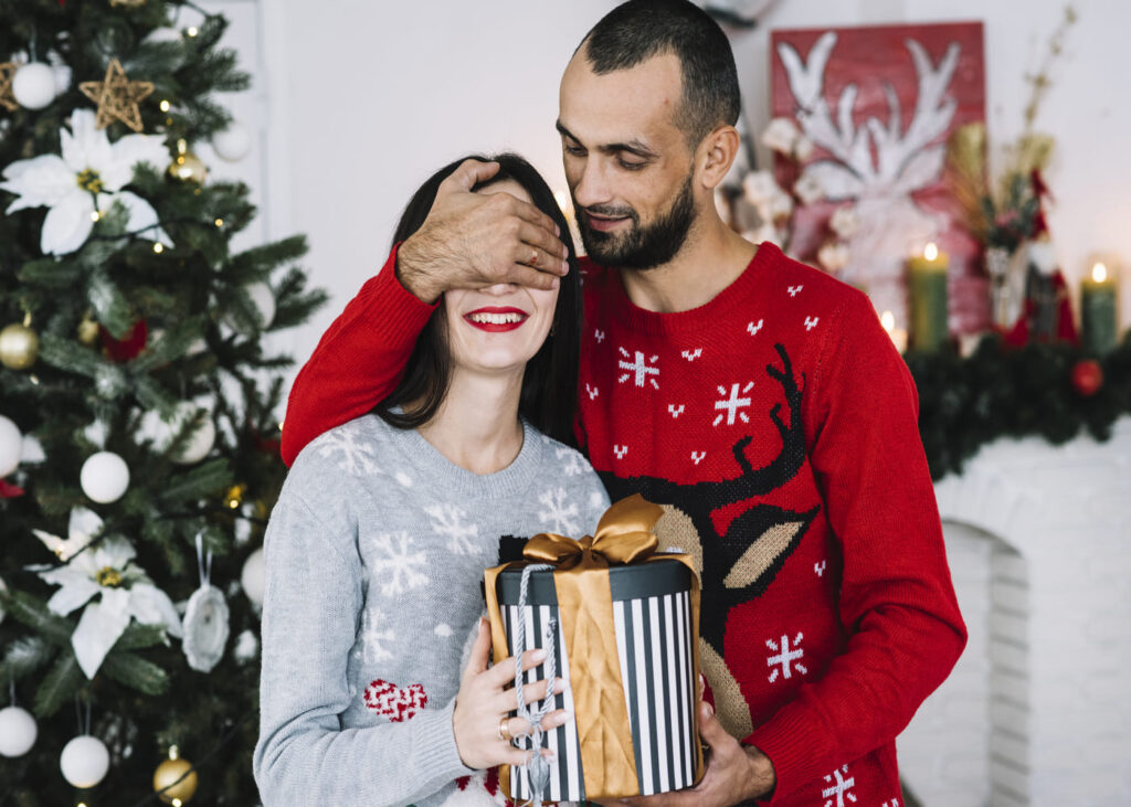 chico-que-sorprende-a-su-novia-tapandole-los-ojos-para-entregarle-su-regalo-de-navidad