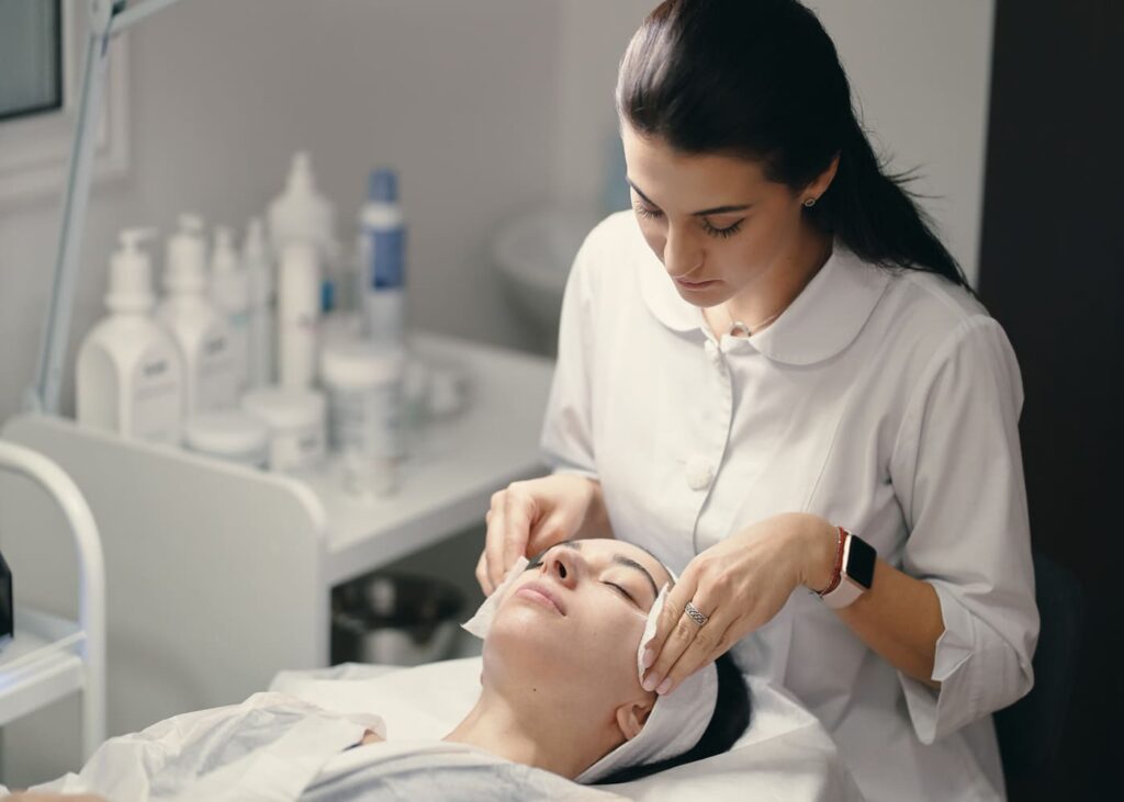 cosmetóloga-que-realiza-un-tratamiento-facial-a-su-clienta-en-su-consulta