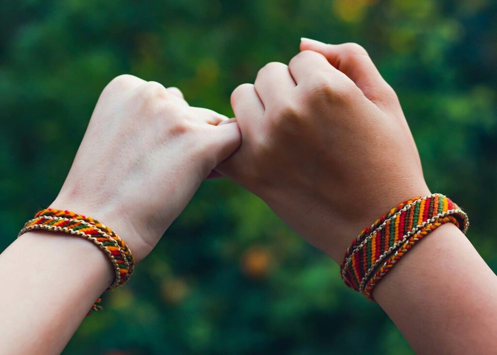 dos-personas-que-se-estrechan-el-dedito-con-una-pulsera-de-la-amistad-en-cada-muneca