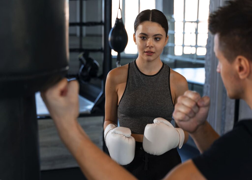 entrenador-de-boxeo-que-ensena-tecnicas-a-una-mujer-que-lleva-guantes-de-boxeo
