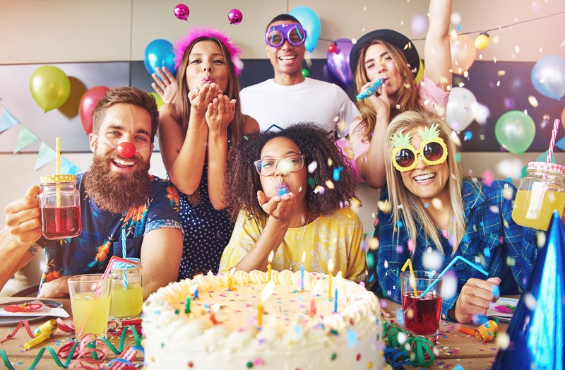 grupo-de-amigos-que-celebran-un-cumpleanos-con-un-pastel-y-decoraciones