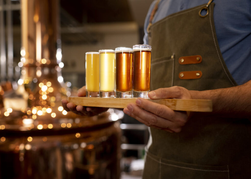 hombre-que-sostiene-una-bandeja-de-cervezas-artesanales-por-un-hombre-con-delantal