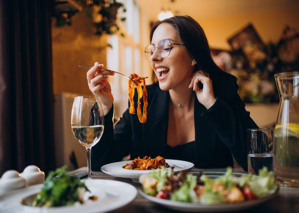 joven-con-gafas-que-come-pasta-en-un-restaurante