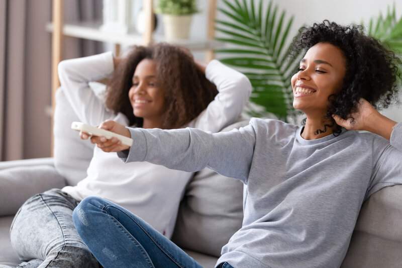 madre-e-hija-en-el-sofa-que-encienden-la-television