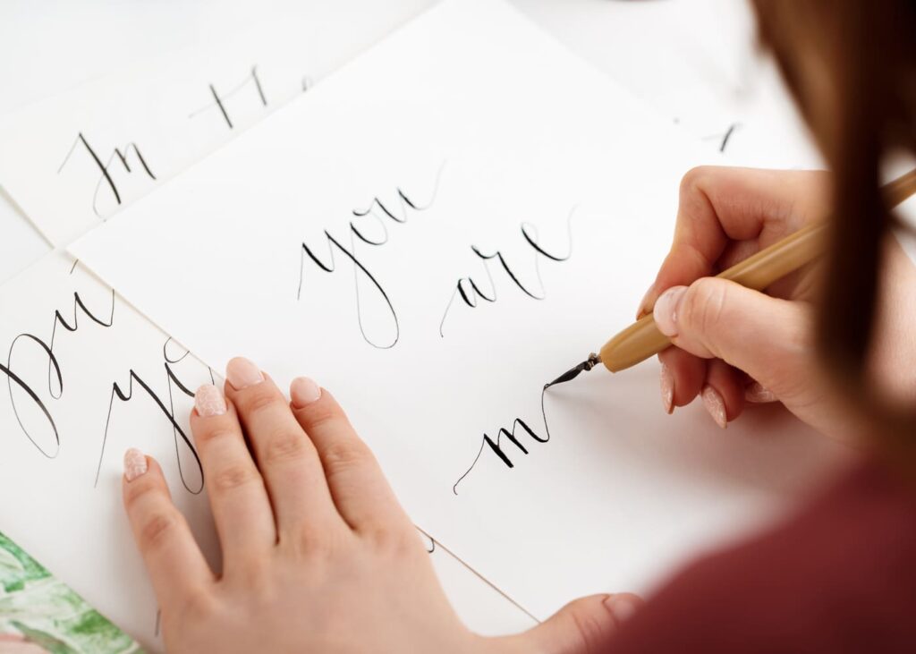 mujer-que-escribe-letras-en-caligrafía-en-una-hoja