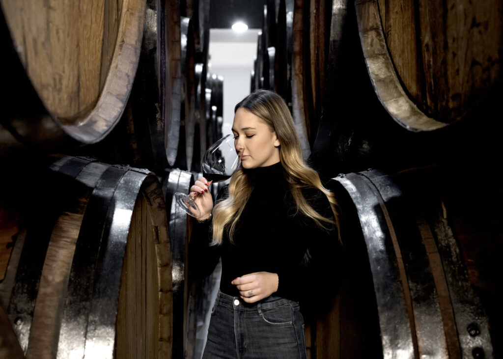 mujer-que-huele-su-copa-de-vino-en-una-bodega