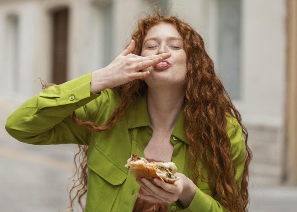 mujer-que-sonrie-mientras-come-un-bocadillo