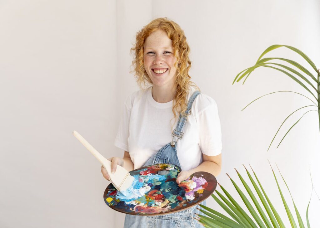 mujer-que-sonríe-sujetando-una-paleta-de-pintura