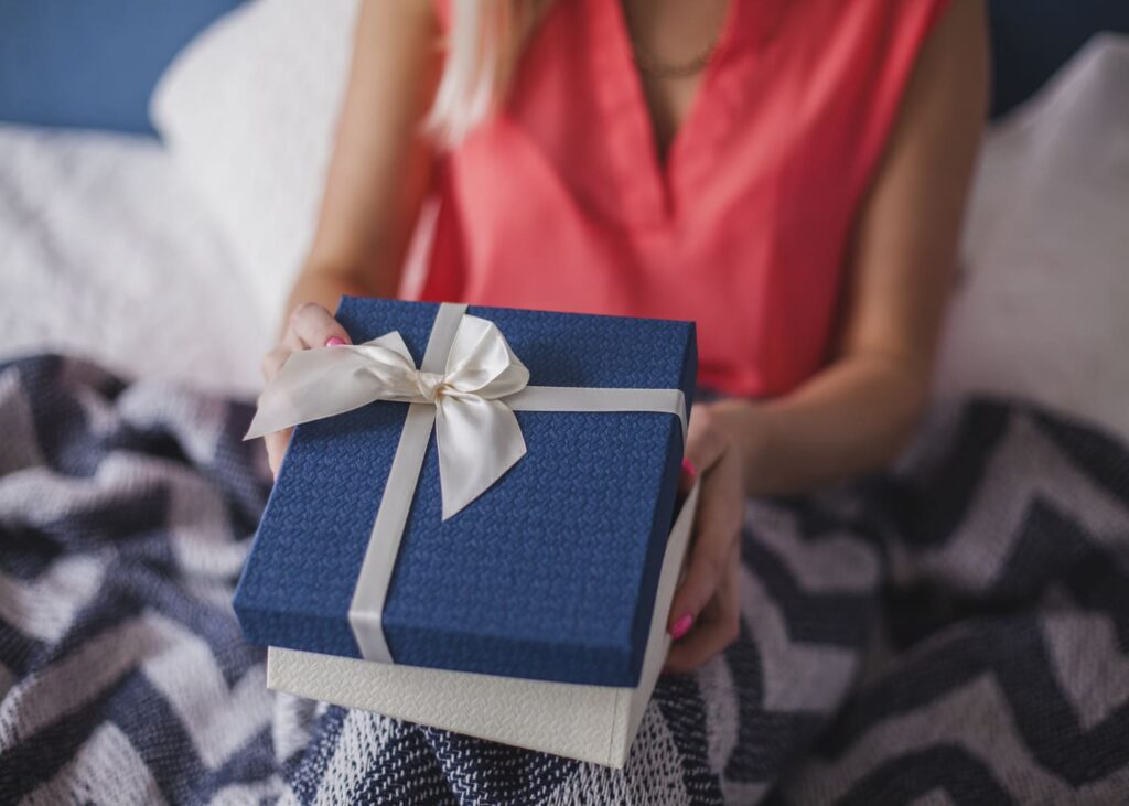 mujer-que-sostiene-un-regalo-azul-en-las-manos
