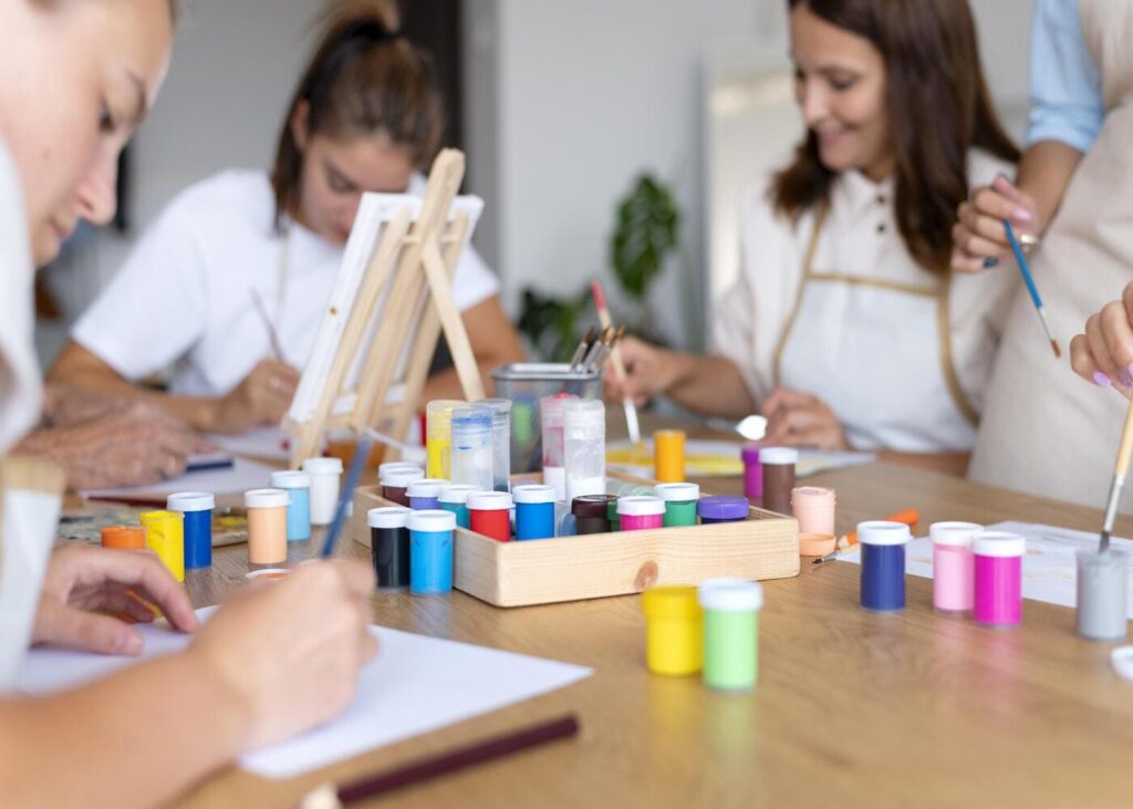 mujeres-que-pintan-todas-juntas-alrededor-de-una-mesa