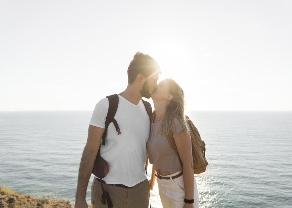 pareja-que-se-besa-frente-al-mar-bajo-el-sol