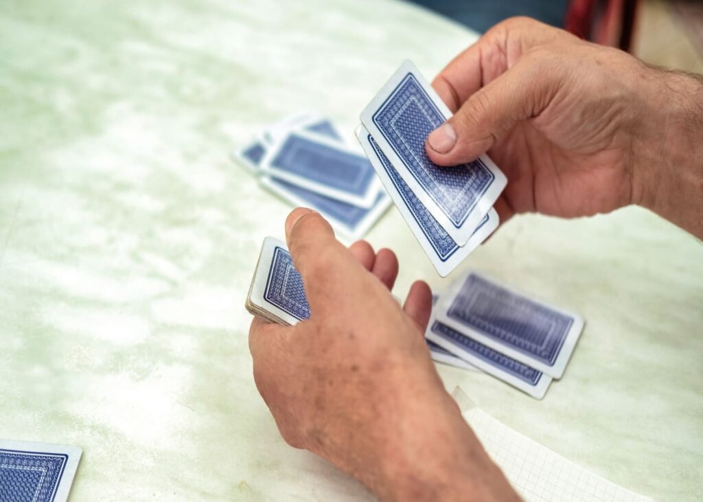 primer-plano-de-manos-de-hombre-jugando-a-las-cartas