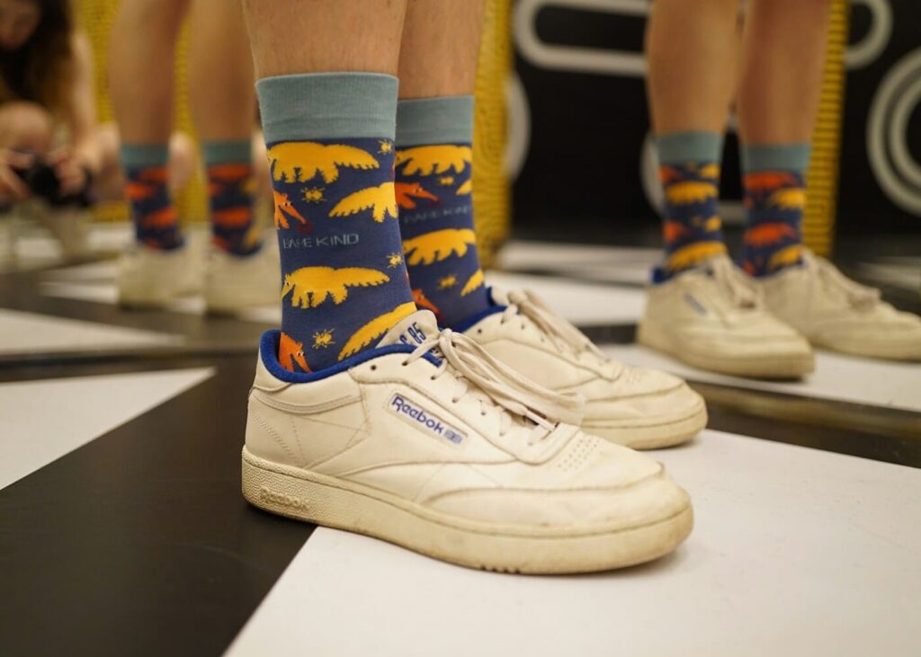 primer-plano-de-piernas-con-calcetines-fantasia-y-zapatillas-blancas