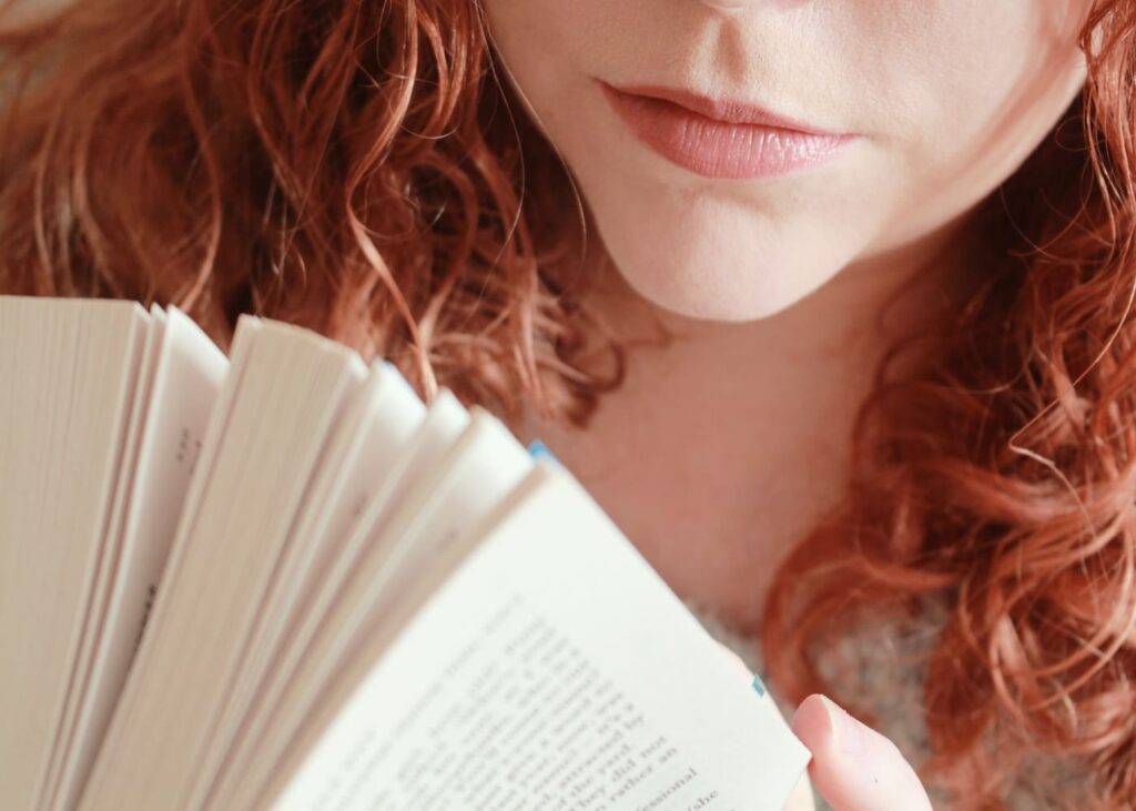 primer-plano-de-una-joven-chica-pelirroja-que-sostiene-un-libro-entre-sus-manos