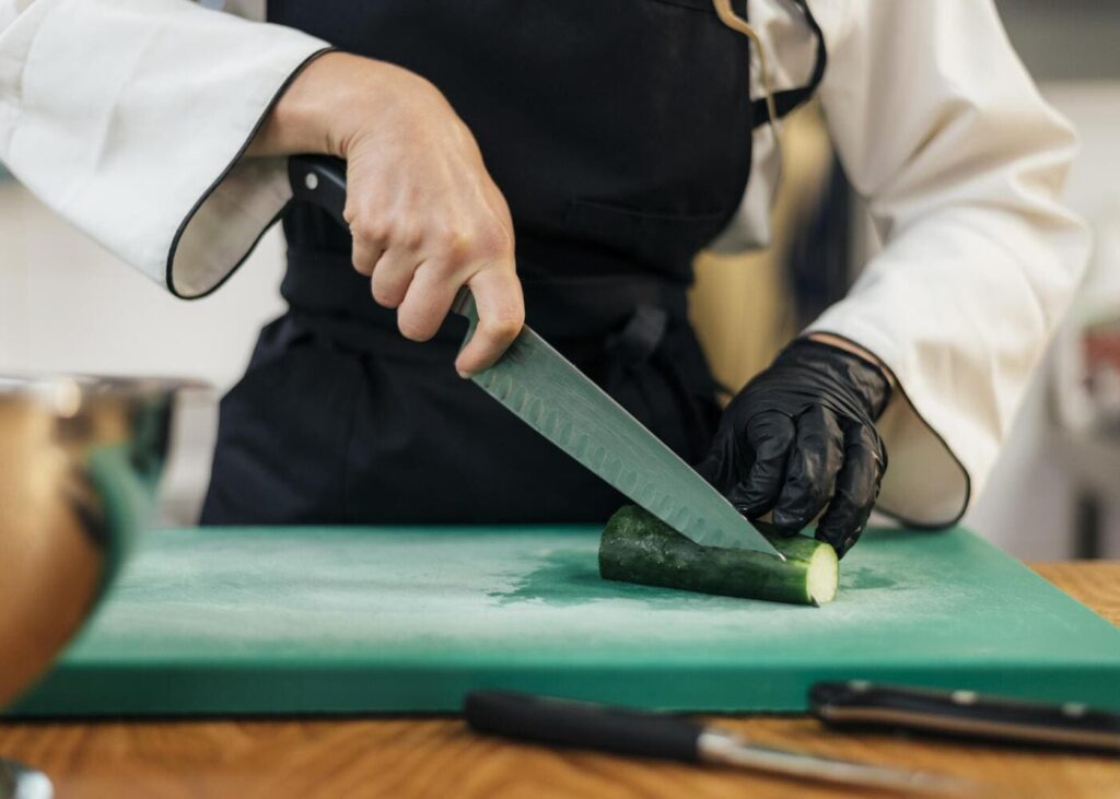 primer-plano-de-una-mujer-chef-que-corta-un-pepino