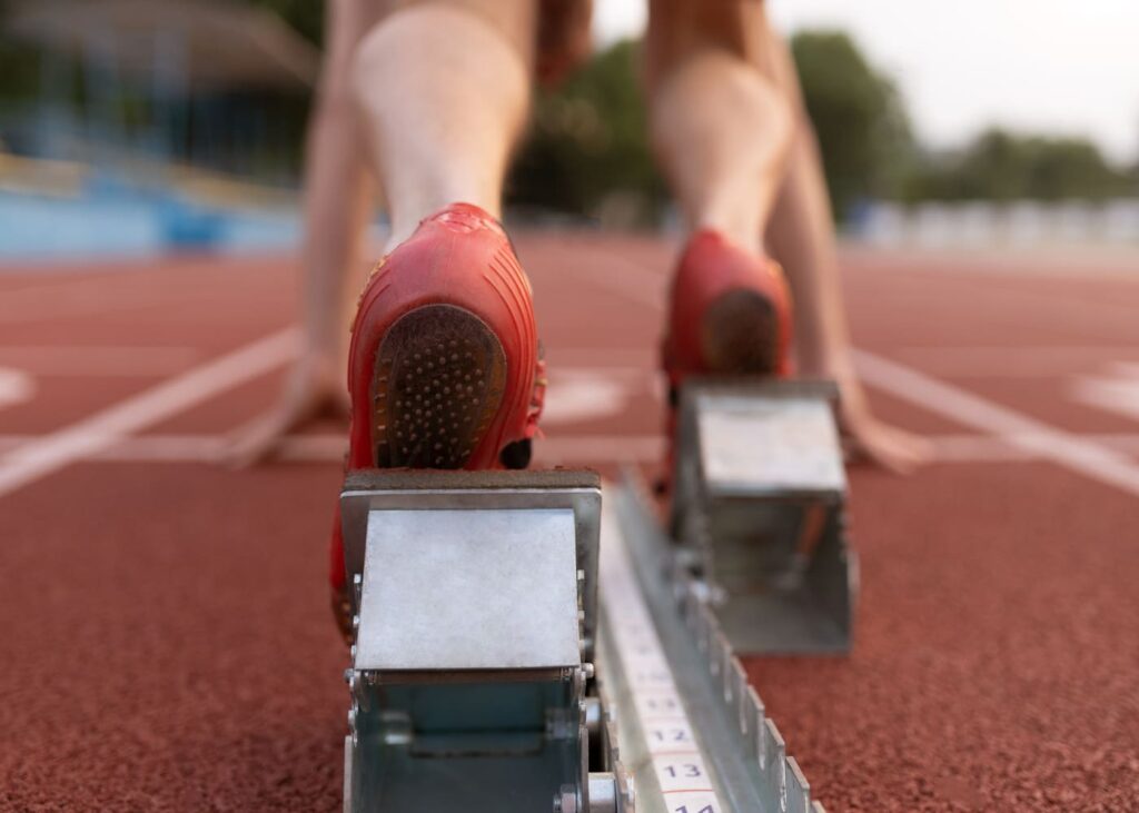 primer-plano-de-zapatillas-de-una-persona-en-la-linea-de-salida-en-una-pista-de-atletismo