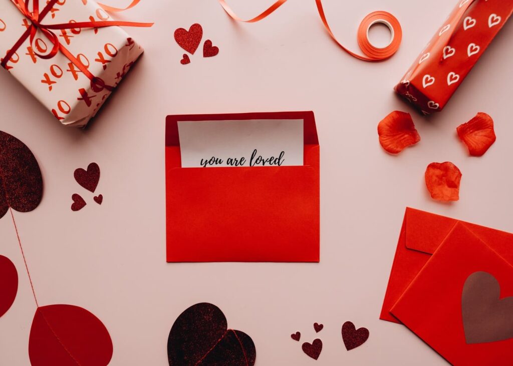 sobre-con-carta-con-una-palabra-de-amor-rodeada-de-decoraciones-romanticas