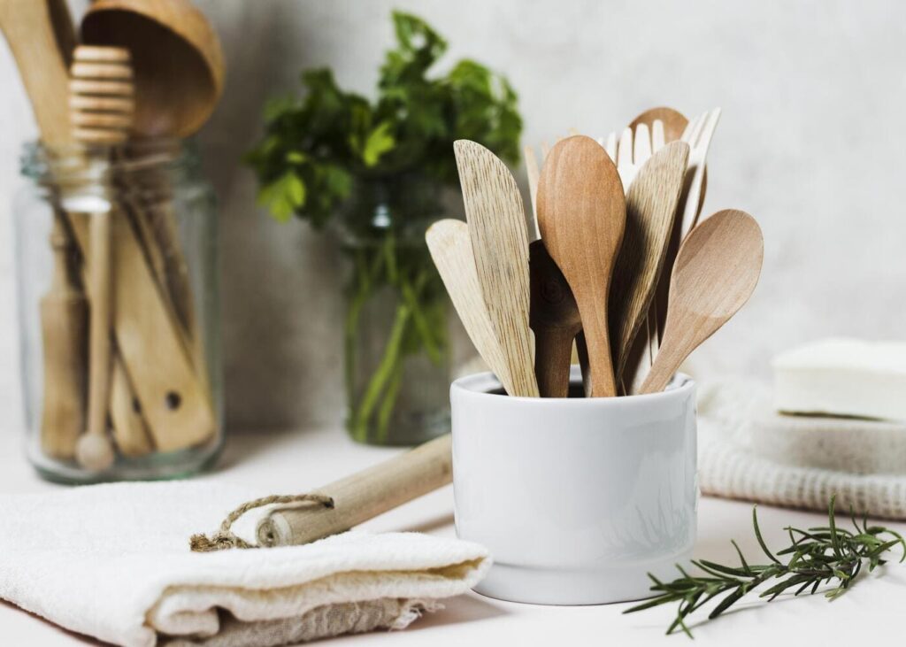 utensilios-de-cocina-en-un-bote-blanco-sobre-la-encimera