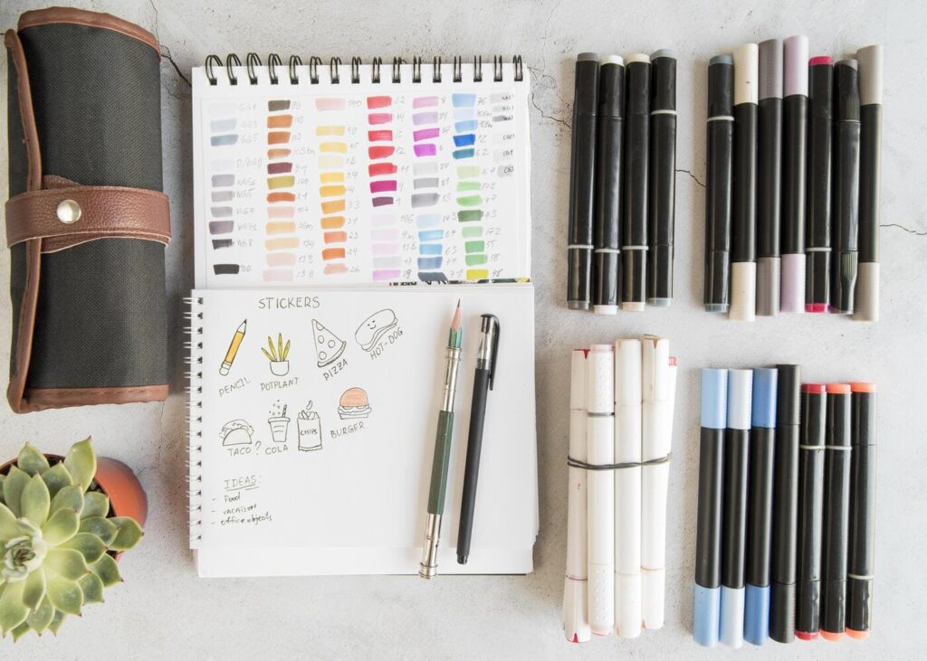 vista-desde-arriba-de-un-cuaderno-de-dibujo-con-rotuladores