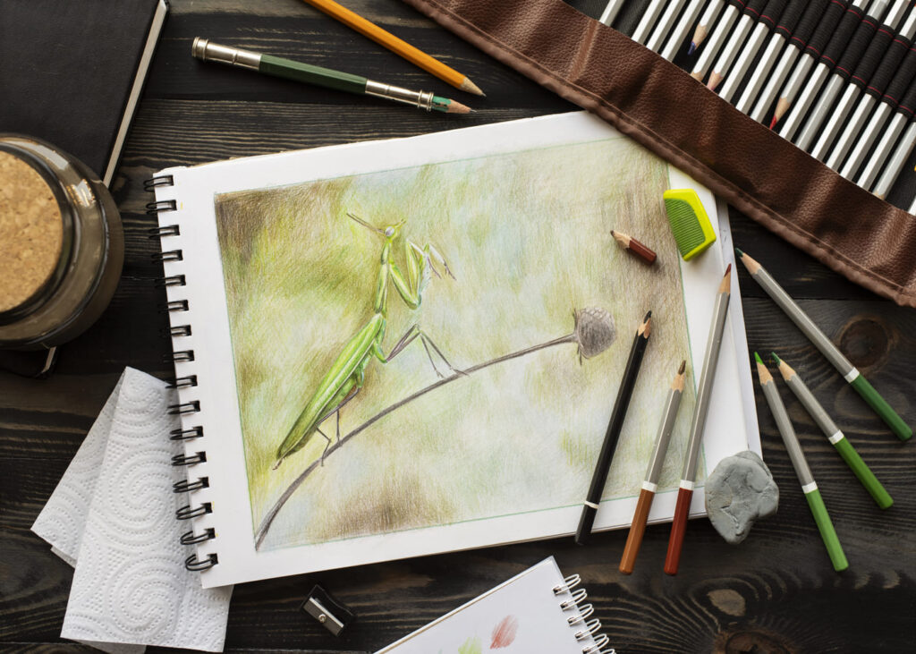 vista-desde-arriba-de-un-dibujo-en-un-cuaderno-de-bocetos-con-lápices