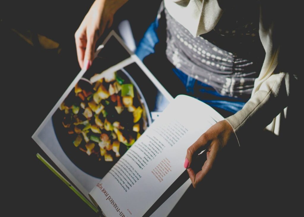 vista-desde-arriba-de-una-mujer-que-hojea-un-libro-de-recetas