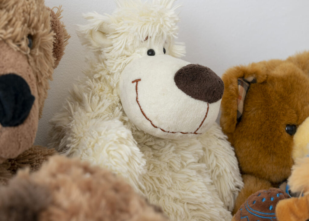 primer-plano-de-un-oso-de-peluche-blanco-rodeado-de-otros-peluches